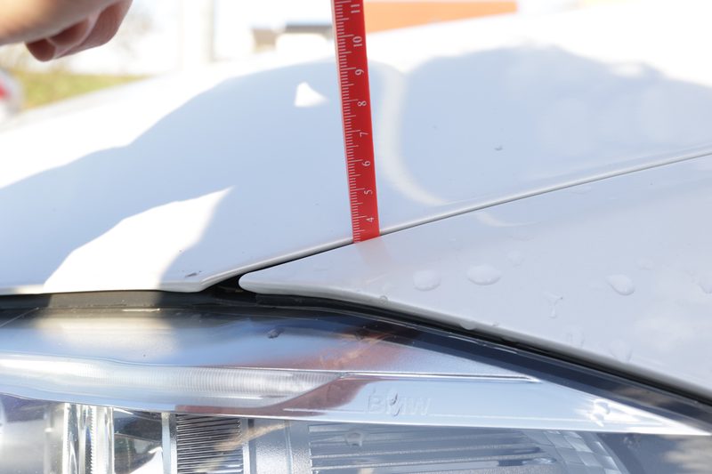 Messlehre an Motorhaube - präzise Schadensmessung